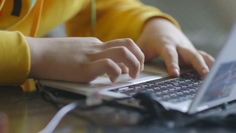 Close-up-of-a-boy's-hands-on-a-laptop-keyboard