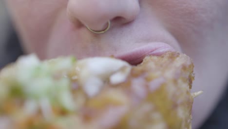 Close-up-slow-motion-of-woman-with-nose-ring-eating-stinky-tofu-with-vegetables-in-Taiwan