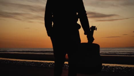 Man-running-with-guitar-in-back-sand-beach-at-sunset-23