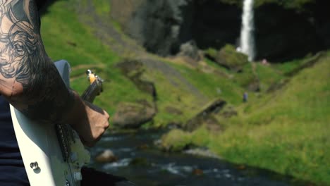Man-playing-guitar-in-front-of-a-beautiful-waterfall-in-Iceland-25
