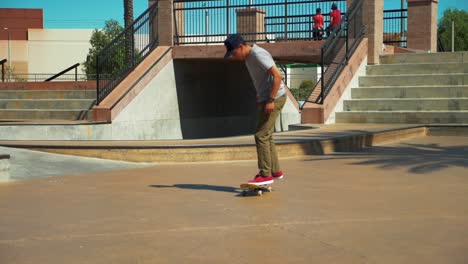 Slow-Motion-shot-of-young-male-Skateboarder-Riding-Skateboard-at-Skate-Park-performing-a-trick