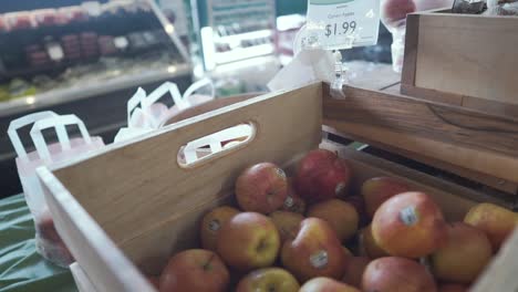 At-the-Supermarket:-Slow-dolly-in-on-a-box-of-apples-and-plums-with-prices-at-the-attractive-grocery-store-market