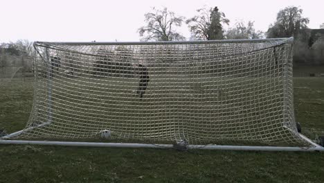 SLOW-MOTION:-A-man-kicks-a-soccer-ball-which-slams-an-icy-net-of-a-soccer-goal-exploding-shattered-ice-into-the-air-1