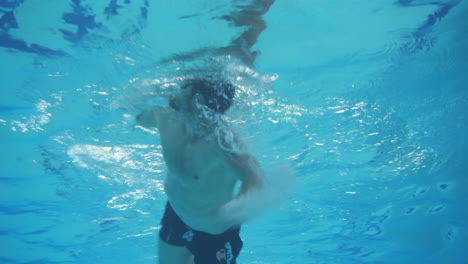 Unterwasseraufnahme-Aus-Niedrigem-Winkel-Eines-Mannes,-Der-Mit-Freestyle-Technik-Schwimmt