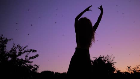 Connecting-With-Nature---A-Beautiful-Woman-Dancing-To-The-Tune-Of-The-Purple-Heaven-During-Sunset-With-Bats-Flying-Overhead
