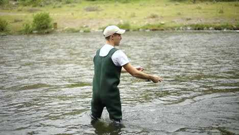 Slow-Motion-Shot-of-a-Caucasian-male-fisherman-casting-his-hook-while-Fly-Fishing-13