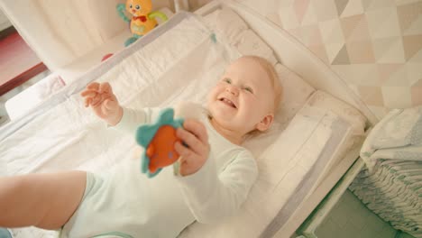 Happy-Baby-girl-smiling-at-home-on-a-changing-mat
