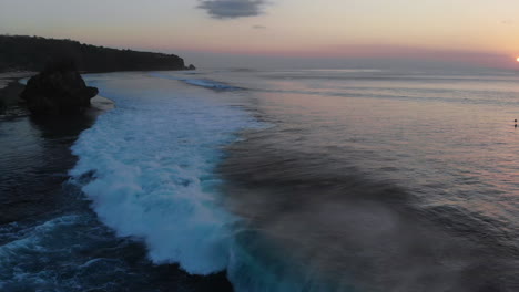 Eine-Einzigartige-Aufnahme-Einer-5-6-Fuß-Welle,-Die-Nahe-Am-Ufer-Bricht,-Natur,-Offener-Ozean,-Unglaublicher-Sonnenuntergang-Und-Surfer-Im-Hintergrund