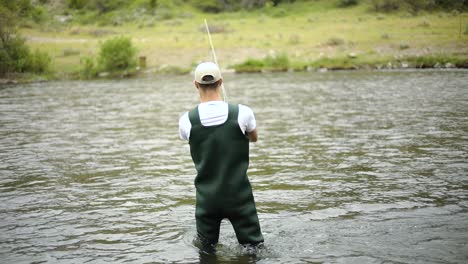 Slow-Motion-Shot-of-a-Caucasian-male-fisherman-casting-his-hook-while-Fly-Fishing-12