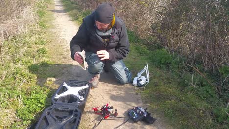 Male-packing-away-drone-after-flying,-putting-equipment-into-safety-backpack