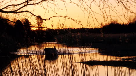 Sommernächte-In-Finnland,-Silhouette-Person,-Die-Boot-Auf-Ruhigem-Fluss-Bei-Sonnenuntergang-Der-Goldenen-Stunde-Fährt