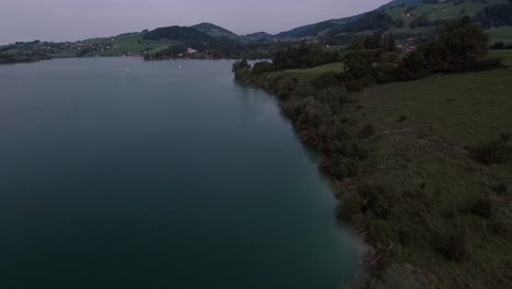 Vuelo-Junto-A-La-Costa-Sobre-La-Naturaleza,-Lago-Gruyère,-Suiza-1