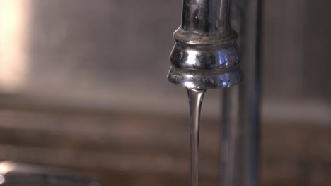 Water-Flowing-From-The-Stainless-Faucet-Into-The-Sink