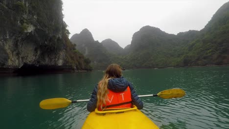 Chica-En-Kayak-En-El-Lago-Frente-A-Montañas-Verdes
