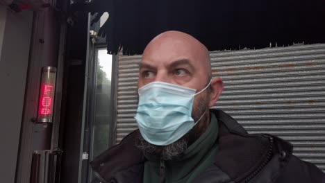 Male-opening-car-wash-workplace-wearing-PPE-corona-virus-face-mask-at-stop-sign