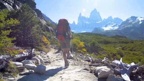 Young-woman-wearing-backpack-walking-on-a-trail-in-Patagonia,-Argentina