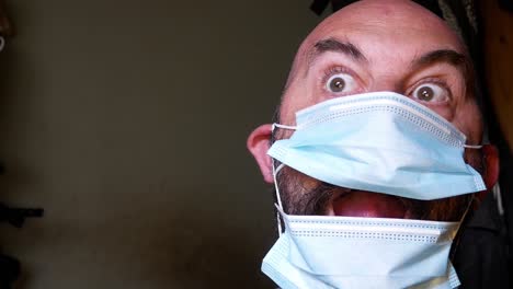 Closeup-Comedy-Männliche-Überraschung-Posiert-In-Medizinischer-PSA-Corona-Virus-Maske-Und-Schaut-In-Den-Kameraraum,-Um-Platz-Für-Kopien-Zu-Finden
