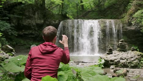 Photographer-working-out-his-polarizing-filter-with-a-beautiful-waterfall-in-the-background