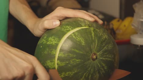 Hand-Holding-A-Sharp-Knife-Slicing-Off-The-Ends-Of-A-Watermelon---Closeup-Shot