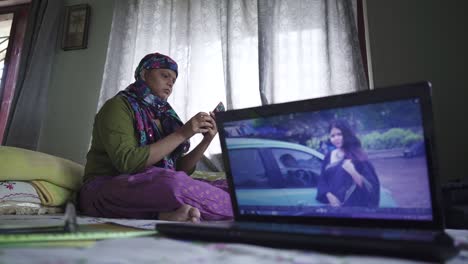 Kahles-Asiatisches-Mädchen,-Das-Sich-Zu-Hause-Mit-Kopftuch-Nach-Der-Chemotherapie-Selbst-Macht,-Altes-Foto-Auf-Dem-Laptop-Bildschirm