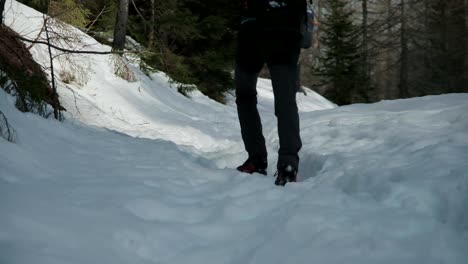 Low-camera-angle-with-a-man-walking-in-deep-snow
