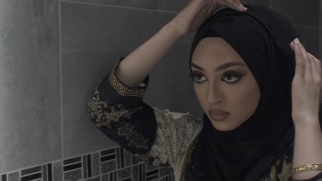 Junge-Muslimische-Frau,-Die-Hijab-Fixiert-Und-In-Den-Spiegel-Schaut