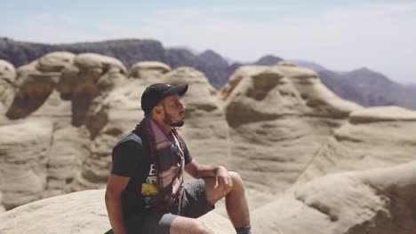 Adventurer-enjoying-the-views,-mountains-background,-peaceful-atmosphere,-nature-reserve-in-Jordan,-static-shot