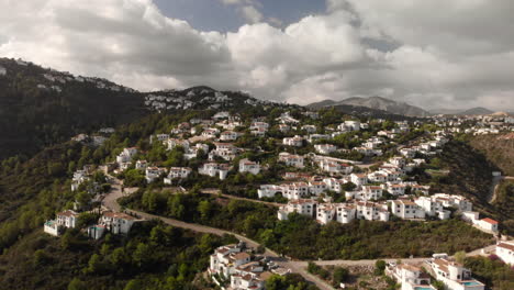 Rising-aerial-small-town-mountains-white-houses-green-trees-day-cloudy