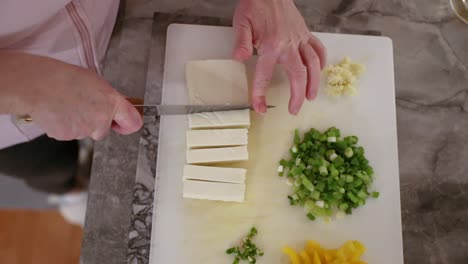 Top-Down-View-Of-Woman-Cutting-Paneer-In-Slow-Motion