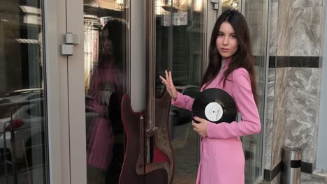 Gorgeous-girl-in-pink-near-the-music-store-with-a-disc