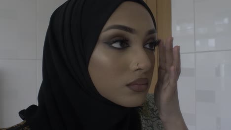 Junge-Muslimische-Frau,-Die-Make-up-überprüft,-Während-Sie-In-Den-Spiegel-Schaut