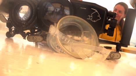 Vintage-Ovale-Tauchermaske-Und-Unterwasserkameragehäuse-Mit-Weiblicher-Taucherin-Im-Hintergrund