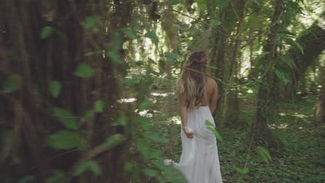 Cheerful-blonde-girl-in-white-dress-in-fantasy-forest-on-Maui-,-Hawaii