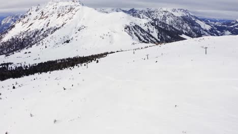 Aerial-orbiting-track-shot-showing-one-person-alone-on-the-snowy-slope-skiing-ski-in-the-mountains