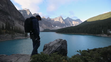 Touristischer-Fotograf,-Der-Szenische-Aussicht-Mit-Berglandschaft-Im-Hintergrund-Im-Moränensee,-Alberta,-Kanada-Einfängt