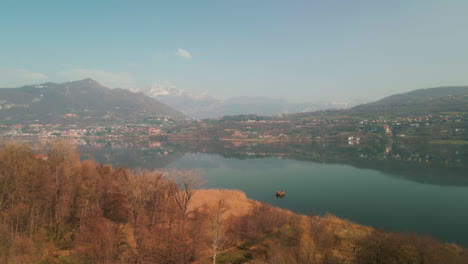 Beautiful-Landscape-View-Of-Idyllic-Lake-With-Mountains-In-Background-In-Annone-Lake,-Northern-Italy---aerial-drone-ascending
