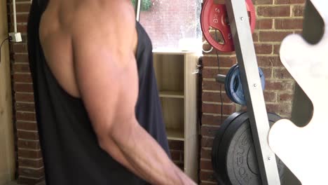Muscly-man-in-home-gym-exercising-bicep-curl-barbell-smith-machine