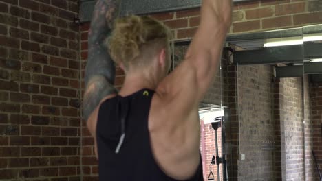 Muskulöser-Mann-Im-Heimfitnessstudio-Trainiert-Hantel-Arnold-Press-Schulterheben
