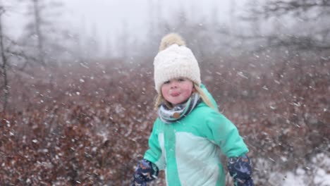 Little-girl-running-snowstorm-focus-from-snow-to-girl-slomo