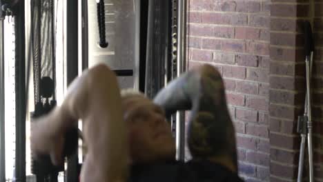 Muscly-man-in-home-gym-exercising-blurry-dumbbell-tricep-skull-crusher
