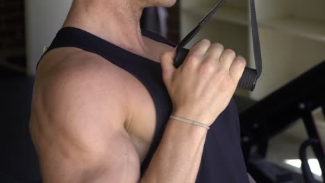Muscly-man-in-home-gym-exercising-shot-from-side-lat-pull-down-cable-machine