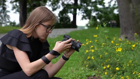 Profil-Einer-Jungen-Fotografin-Mit-Kamera,-Die-Blumen-Im-Park-In-Zeitlupe-Fotografiert