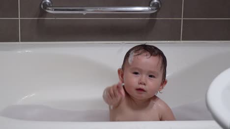 Gemischtes-Asiatisches-Kleinkind-Baby,-Das-Beim-Baden-In-Einer-Schaumigen-Badewanne-Im-Badezimmer-In-Die-Hände-Klatscht