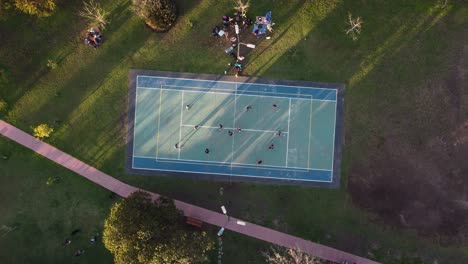 Aerial-top-down-view-directly-above-amateur-volleyball-court-and-players-in-park