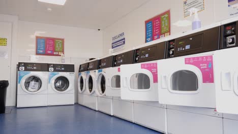 Laundromat-launderette-with-row-of-washing-machines-at-low-angle