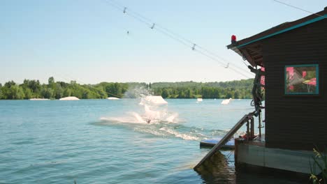 Man-Pulled-By-Cable-For-Water-Ski-Lift-Fall-In-The-Lake-Water-Of-Cergy-Pontoise-Leisure-Island-In-Paris,-France