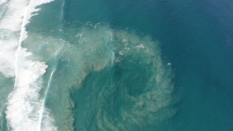 Top-view-of-blue-moving-ocean-waves-and-sand-next-to-the-big-beautiful-island,-Fraser-Island,-Australia