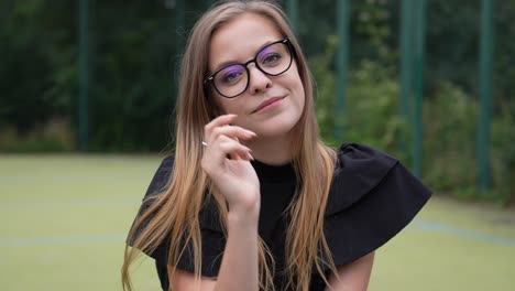 Portrait-of-Happy-Young-Female-Model-Wearing-Glasses-in-Park-and-Looking-at-Camera-With-Smile,-Full-Frame-Slow-Motion