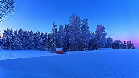 Thermowood-Cabin-And-Barrel-Sauna-Near-Forest-On-A-Snowy-Land-During-Blue-Hour