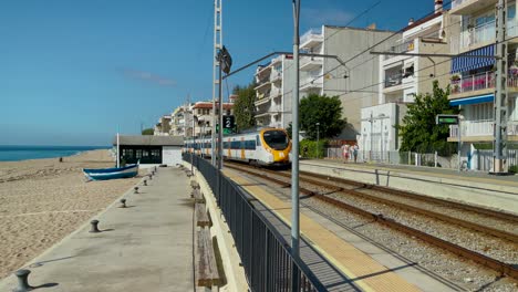Tren-Rodalies-En-La-Costa-Del-Maresme-En-Barcelona-A-Media-Distancia-Pasando-Por-La-Playa-Con-Vistas-Al-Mar